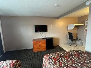 a hotel room with a bed and a flat screen tv at Dream Inn in Tonopah