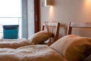 2 letti con cuscini in una camera con finestra di Private house “Ushimado villa”, 10ppl, Parking / BBQ 