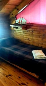 Cama en habitación con pared de madera en Cabañas el Recodo de Potrero in 