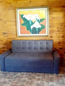 un sofá azul en una habitación con una pintura en la pared en Cabañas el Recodo de Potrero in 