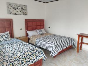 een slaapkamer met 2 bedden en een tafel bij Imelda House in Ayangue