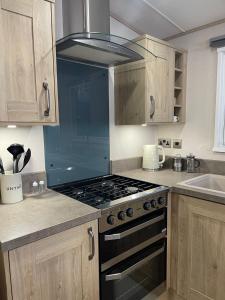 a kitchen with a stove top oven in a kitchen at 3 BR - Luxury Family Home Near The Beach in East Mersea