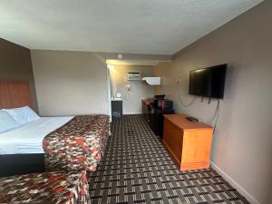 a hotel room with a bed and a flat screen tv at Dream Inn in Tonopah