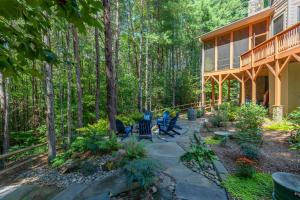 een veranda van een huis met stoelen in het bos bij Sweet Spot on Lake James Luxury Home with Private Dock, Fire Pit & Game Room! in Morganton