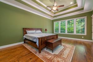 Schlafzimmer mit einem Bett und einem Deckenventilator in der Unterkunft Sweet Spot on Lake James Luxury Home with Private Dock, Fire Pit & Game Room! in Morganton