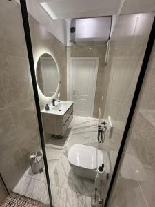 uma casa de banho com uma banheira, um lavatório e um espelho. em Skyen Luxury Apartments em Durrës