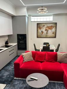 uma sala de estar com um sofá vermelho e uma mesa em Skyen Luxury Apartments em Durrës