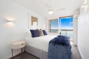 1 dormitorio con 1 cama y vistas al océano en Las Rias Holiday Apartments, en Noosa Heads