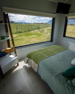 a bedroom with a bed and a large window at Cabañas Julián Elias in Puerto Natales