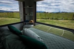 a bedroom with a bed and a large window at Cabaña Julián Elias Verde in Puerto Natales +11 photos