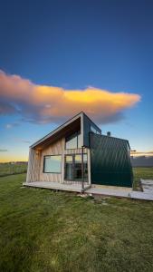 una pequeña casa en un campo con un cielo en Cabañas Julián Elias, en Puerto Natales