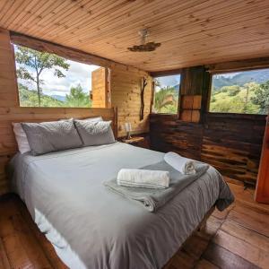 um quarto com uma cama num chalé de madeira em Habitación Colibrí, Pijao, Finca Flora del Río em Pijao