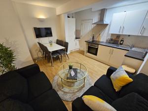 sala de estar con sofá negro y mesa en 2bdr Islington close to station en Londres