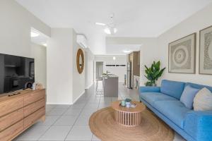 a living room with a blue couch and a table at Botanical- Edge Hill Village in Edge Hill