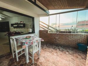 a kitchen with a table and chairs and a window at Casa 3 - Estrela Dalva, vista para o mar! in Farol de Santa Marta