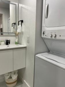 Baño blanco con lavabo y espejo en Magnolias Suite en Lehigh Acres