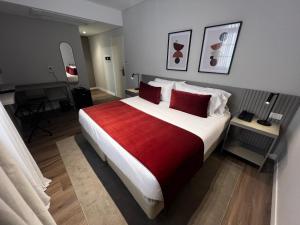 a bedroom with a large bed with a red blanket at Guemes Hotel & Spa in Salta