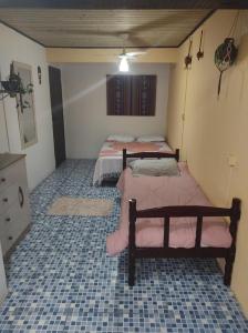 two beds in a room with a tiled floor at Casa 3 - Estrela Dalva, vista para o mar! in Farol de Santa Marta