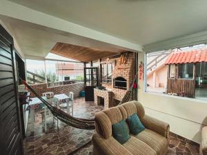 a living room with a couch and a hammock at Casa 3 - Estrela Dalva, vista para o mar! in Farol de Santa Marta