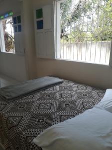 uma cama num quarto com uma janela e um piso em Porto apartamento 6 em Porto Seguro