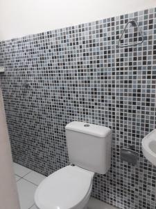 a bathroom with a white toilet and a sink at Porto apartamento 6 in Porto Seguro +15 photos