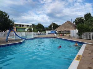 a swimming pool with two people in the water at BABILONIA SEGUNDO PISO in Ricaurte