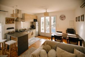 cocina y sala de estar con sofá y mesa en Charming villa in the heart of the watershed, en LʼIsle-sur-la-Sorgue
