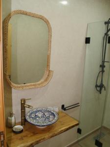 a bathroom with a sink and a mirror on a counter at Dar Makai Surf Hotel in Tamraght Ouzdar