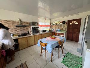 una cocina con una mesa con un bol de fruta. en Toamanahere Guesthouse en Tubuai
