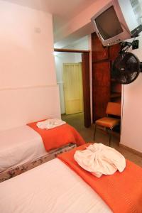 duas camas num quarto com uma televisão na parede em El Pinar em Bialet Massé