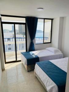Giường trong phòng chung tại Karey 1504 Vista al Mar, El Rodadero Santa Marta