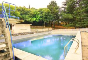 uma piscina com água azul num quintal em El Pinar em Bialet Massé
