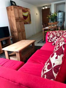 sala de estar con sofá rojo y mesa de madera en Apartment La Serena Pacifico, en La Serena