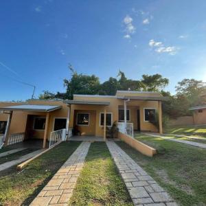 ein kleines gelbes Haus mit einer Einfahrt davor in der Unterkunft Villa Congo by Villas Oasis Guacalillo in Tarcoles