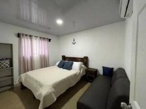 ein Schlafzimmer mit einem Bett und einem Sofa in der Unterkunft Villa Congo by Villas Oasis Guacalillo in Tarcoles