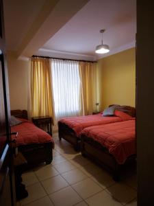 1 dormitorio con 2 camas y ventana en Refugio del Turista en Tupiza