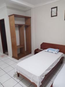 a bedroom with two beds and a wooden cabinet at HOTEL NEW´S BUSINESS in Macapá
