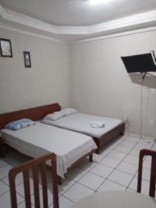 um quarto com duas camas e uma tv nele em HOTEL NEW´S BUSINESS em Macapá