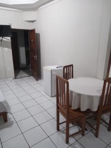 een keuken met een tafel en stoelen en een koelkast bij HOTEL NEW´S BUSINESS in Macapá