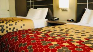 a hotel room with two beds and a phone on a bed at Econo Lodge Inn & Suites in Murfreesboro