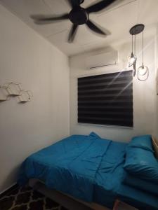 a bedroom with a blue bed and a ceiling fan at DRS Legacy Homestay in Kamunting