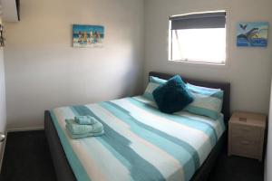 a bedroom with a bed with a stuffed animal on it at Whitianga Kiwi Bach in Whitianga