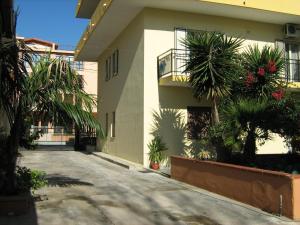 un edificio con palme di fronte di Al Cedir a Reggio di Calabria
