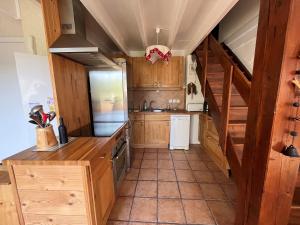 eine Küche mit Holzschränken und einer Treppe in der Unterkunft Duplex T4 au cœur du village, 3 chambres, garage, pour 6/7 pers. - FR-1-761-12 in Villard-de-Lans