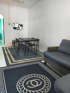- un salon avec une table et un canapé dans l'établissement Homestay Sri Awana, à Alor Setar