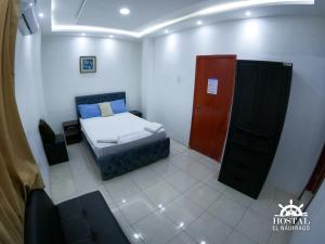 a small room with a bed and a red door at Hostal El Naufrago 1 in Manta