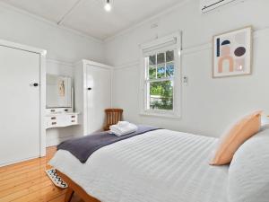 Habitación blanca con cama y ventana en Piper St Cottage, en Yarrawonga