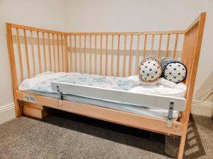 a wooden crib with two balls on top of it at Hillcrest Harmony: Luxury in Westmeadows 20% OFF in Melbourne