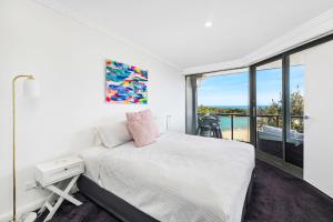 Un dormitorio con una cama y una ventana grande. en Ocean Views, en Boat Harbour