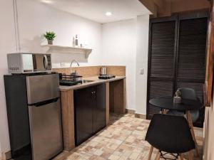 Il comprend une cuisine équipée d'un réfrigérateur et d'une table avec des chaises. dans l'établissement Estudio Bengala, à San José del Cabo